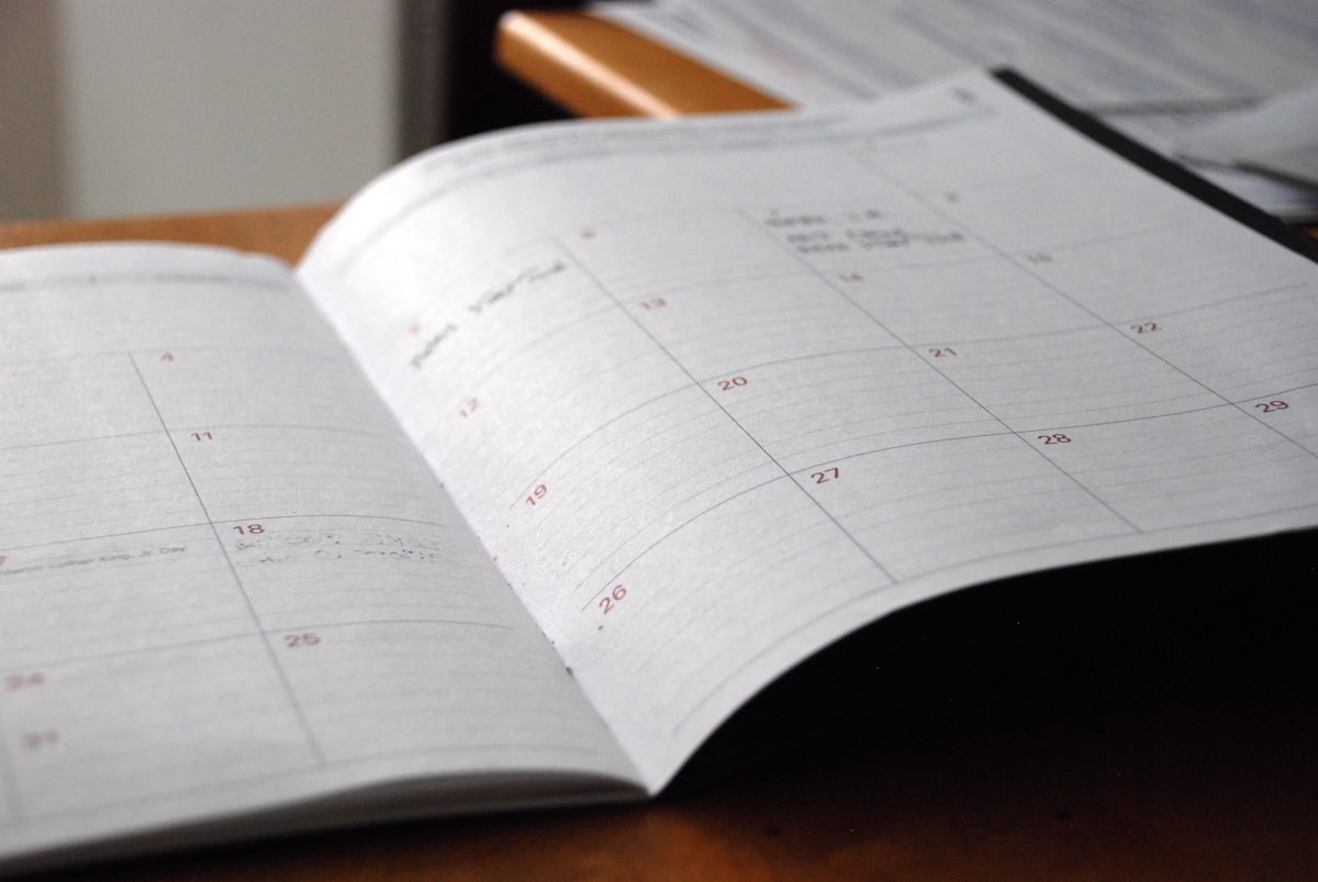 Agenda mensuel ouvert sur un bureau en bois