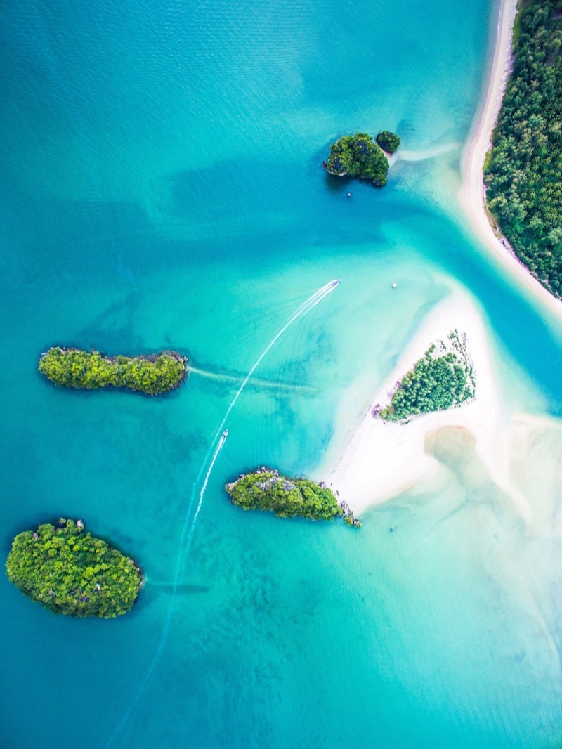 Vue aérienne d'îlots boisés et d'un banc de sable dans une mer turquoise