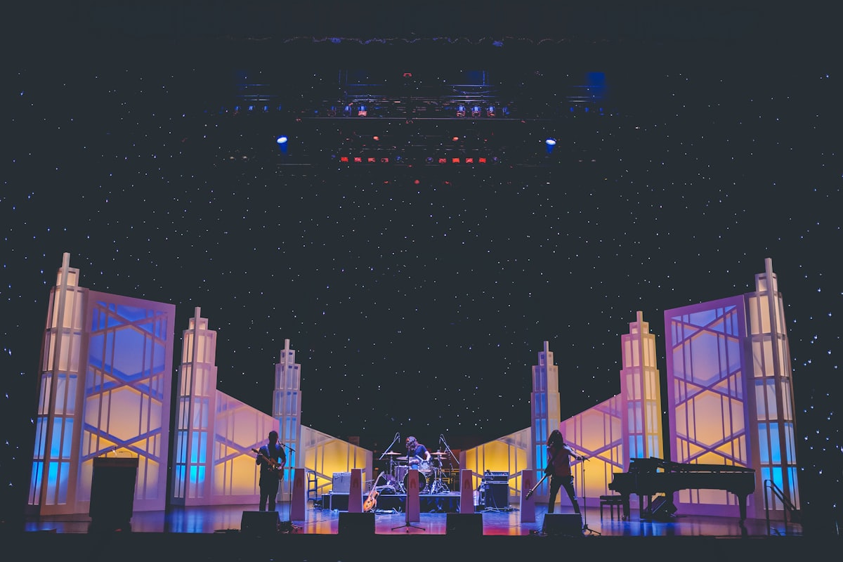 Scène de spectacle éclairée avec décors et musiciens en formation live
