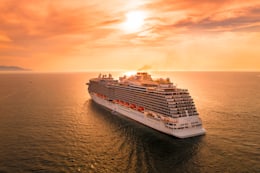 Grand navire de croisière en pleine mer sous un coucher de soleil doré