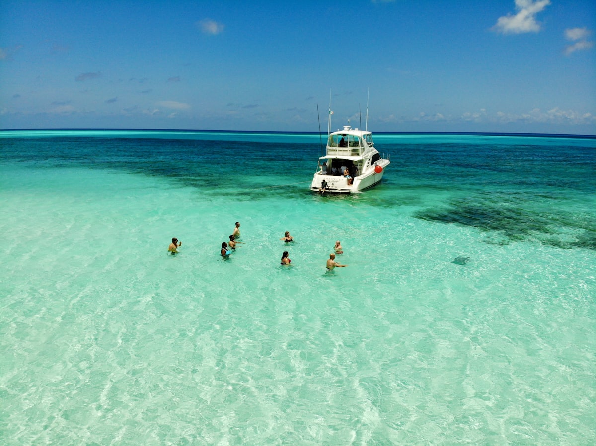 Baigneurs et bateau d'excursion dans les eaux turquoise au large de Cozumel