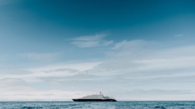 Un petit navire de croisière de luxe au mouillage au large, sous un ciel voilé
