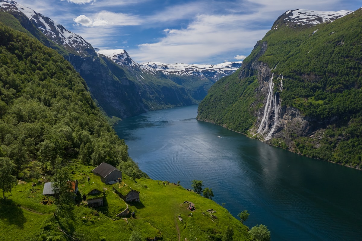 La cascade des Sept Sœurs se jetant dans le Geirangerfjord entre deux parois boisées