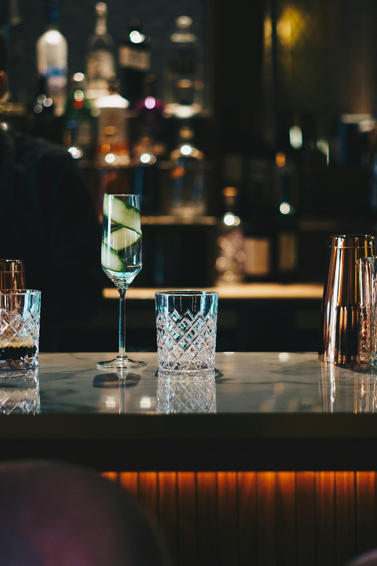 Trois verres de cocktail posés sur un comptoir de bar