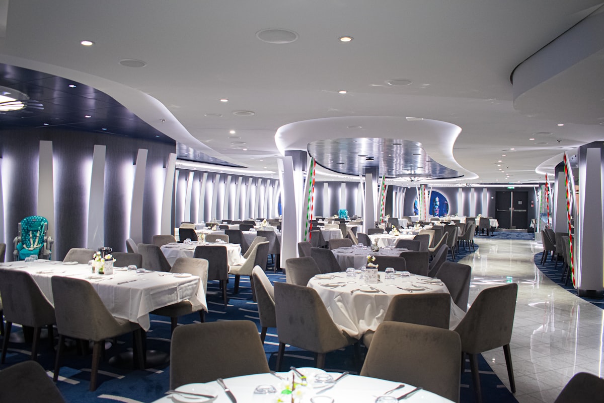 Salle de restaurant principale d'un navire de croisière, tables dressées de blanc