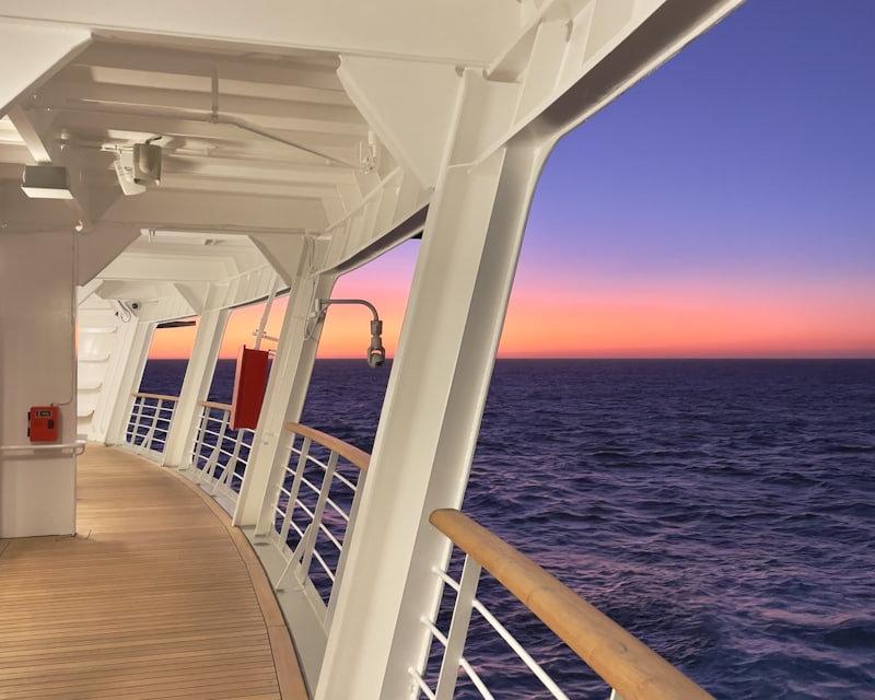 Coursive extérieure d'un navire de croisière au crépuscule, face à l'océan