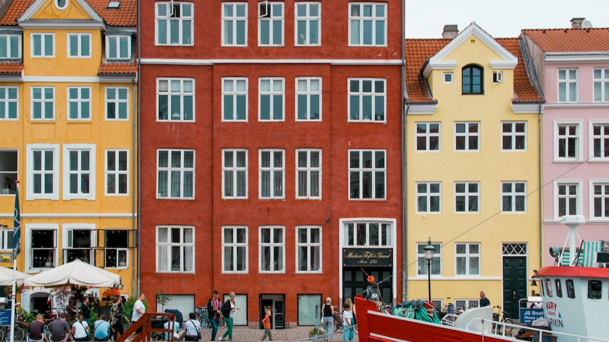 Les façades colorées du canal de Nyhavn à Copenhague, avec la proue d'un bateau rouge au premier plan