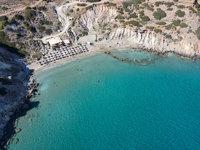 Crique grecque aux eaux turquoise vue du ciel, plage et falaises calcaires