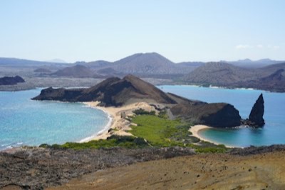 Le rocher Pinnacle et les deux plages de l'île Bartolomé vus du sommet de l'île, avec les volcans de l'archipel à l'arrière-plan