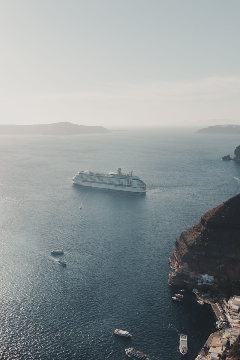 Navire de croisière naviguant dans la caldeira de Santorin, falaises et village perchés en arrière-plan