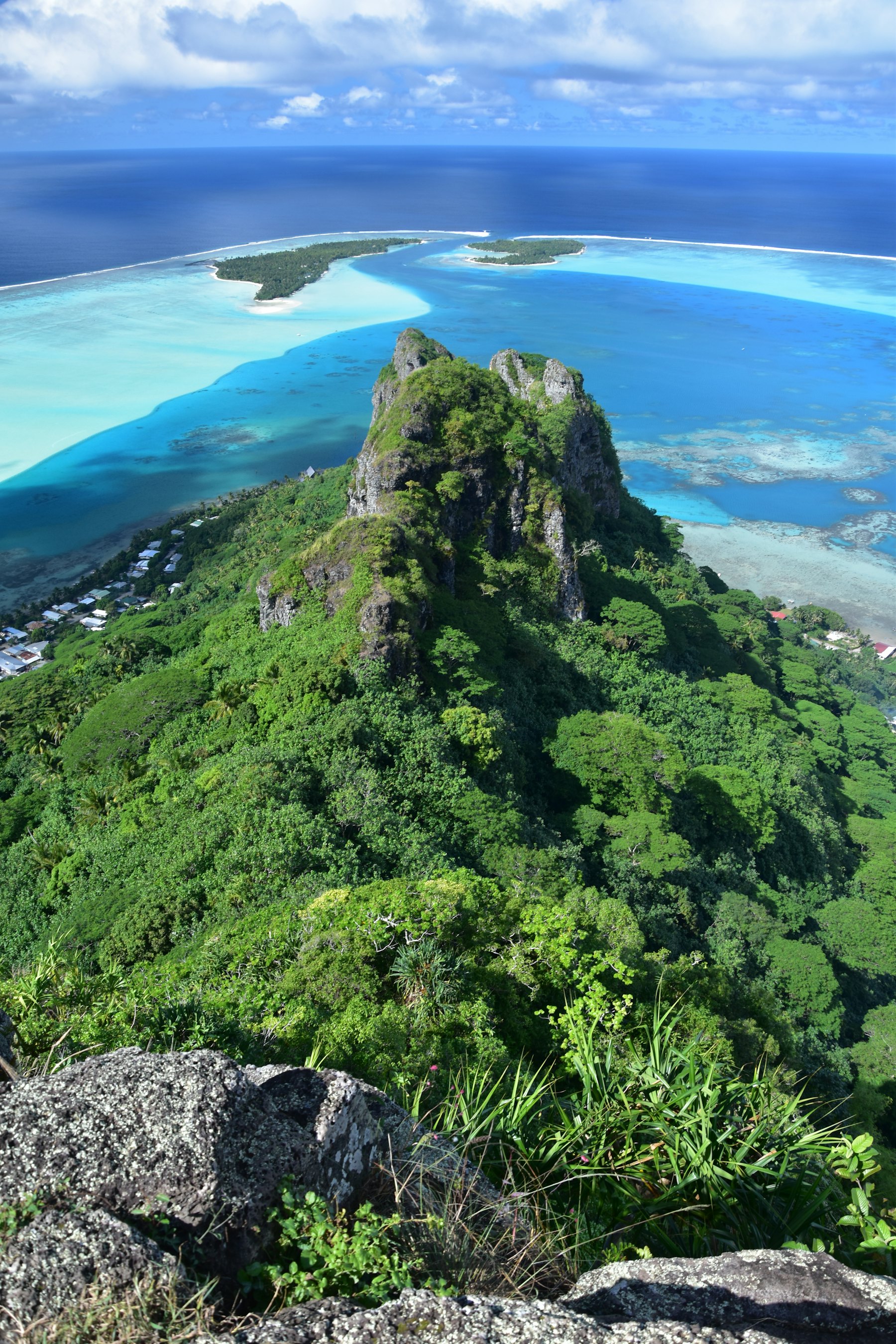 Pic volcanique dominant un lagon turquoise cerné par sa barrière de corail