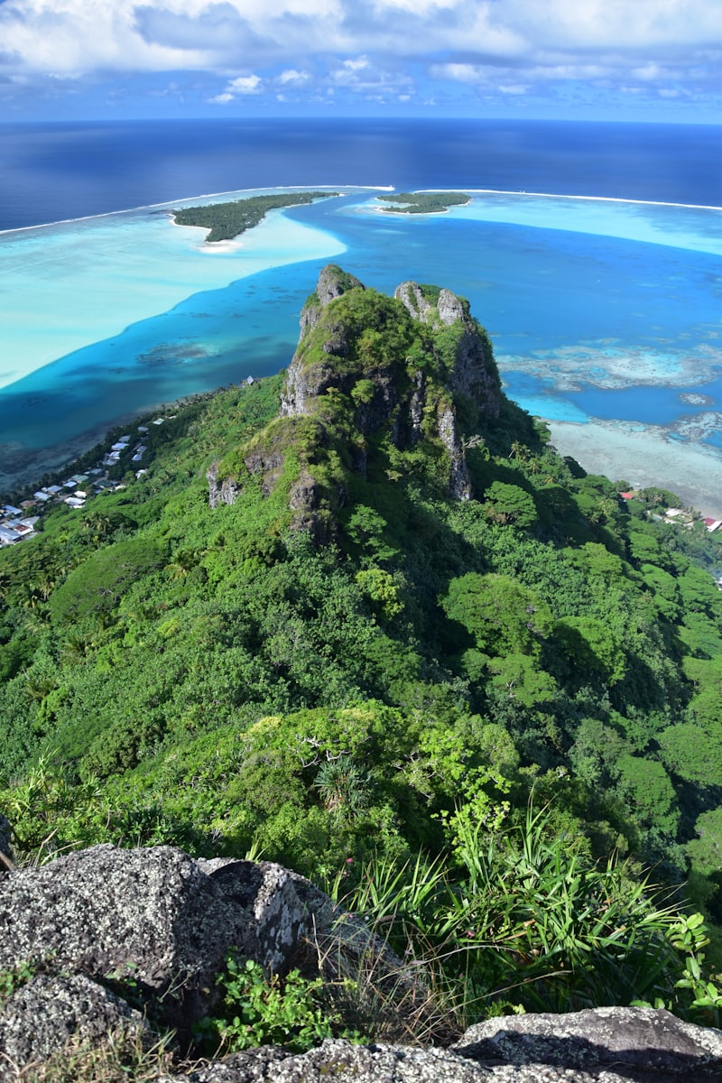 Pic volcanique dominant un lagon turquoise cerné par sa barrière de corail
