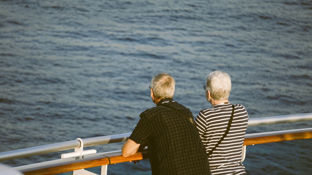 Deux passagers accoudés au bastingage regardant la mer