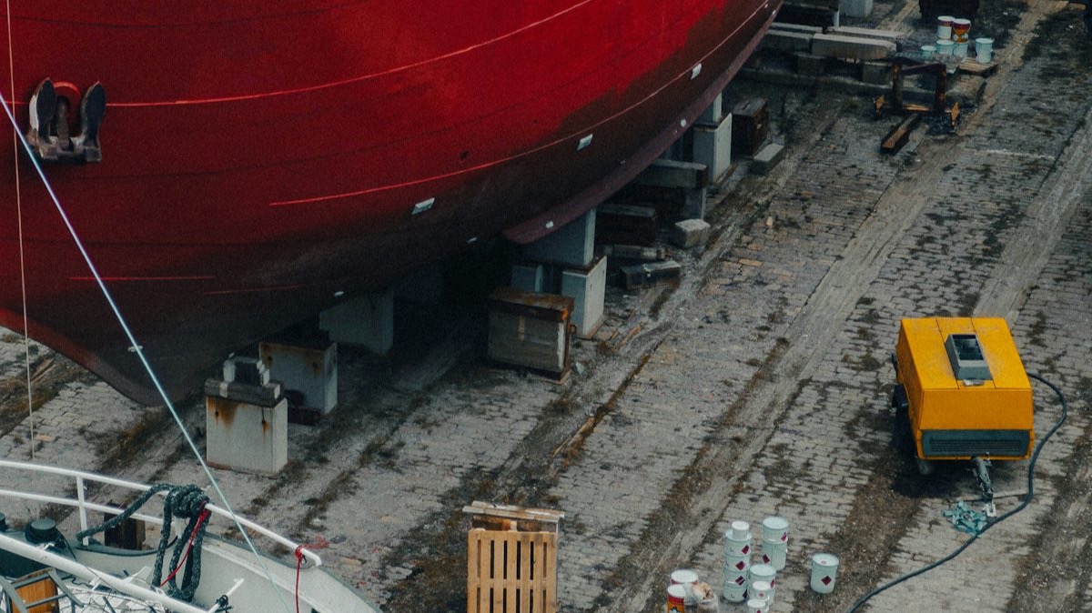 Un navire à coque rouge en cale sèche, vu d'en haut