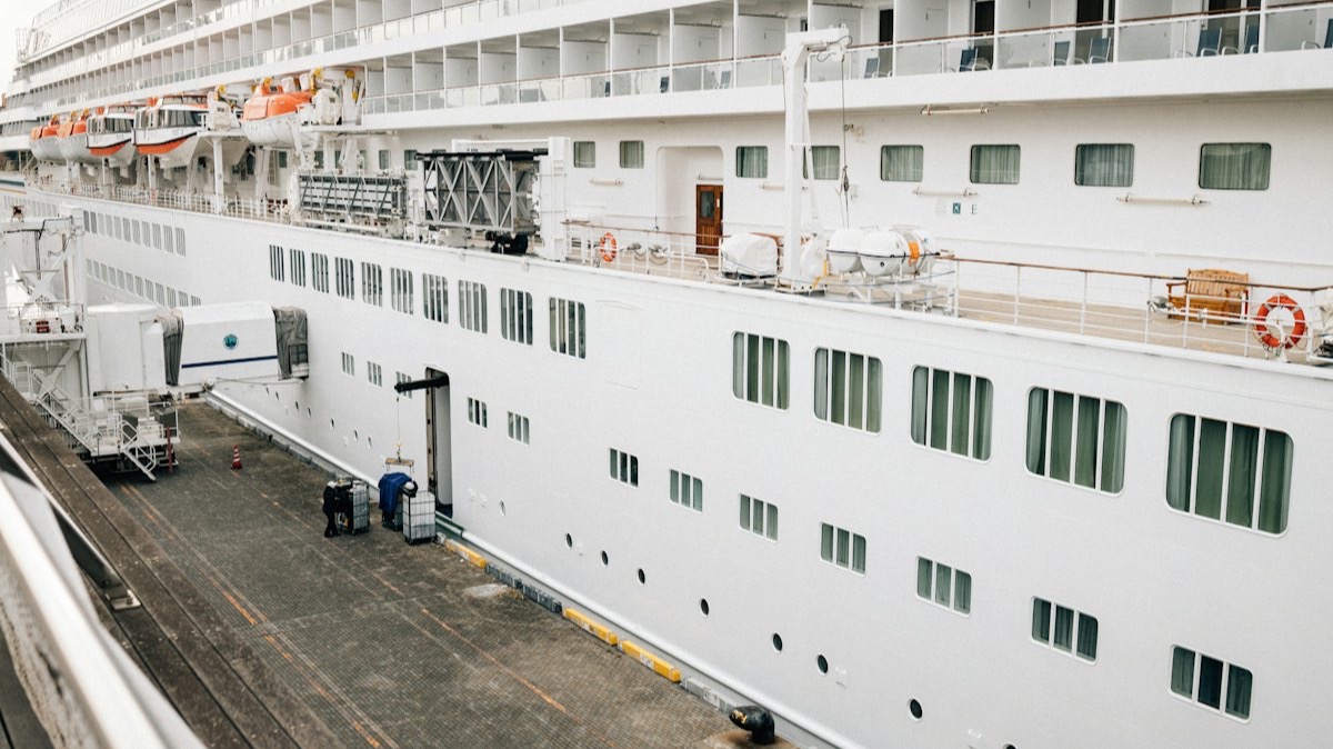 Un navire de croisière à quai, relié au terminal par une passerelle d'embarquement couverte