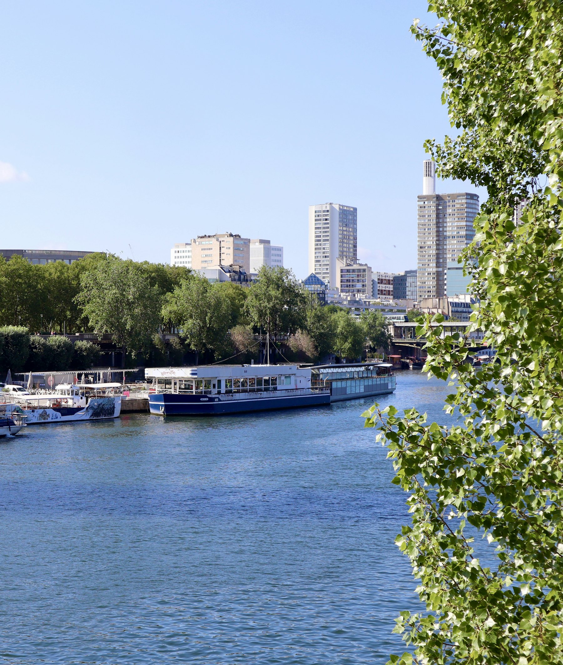 Bateaux fluviaux amarrés le long d'un fleuve traversant une ville