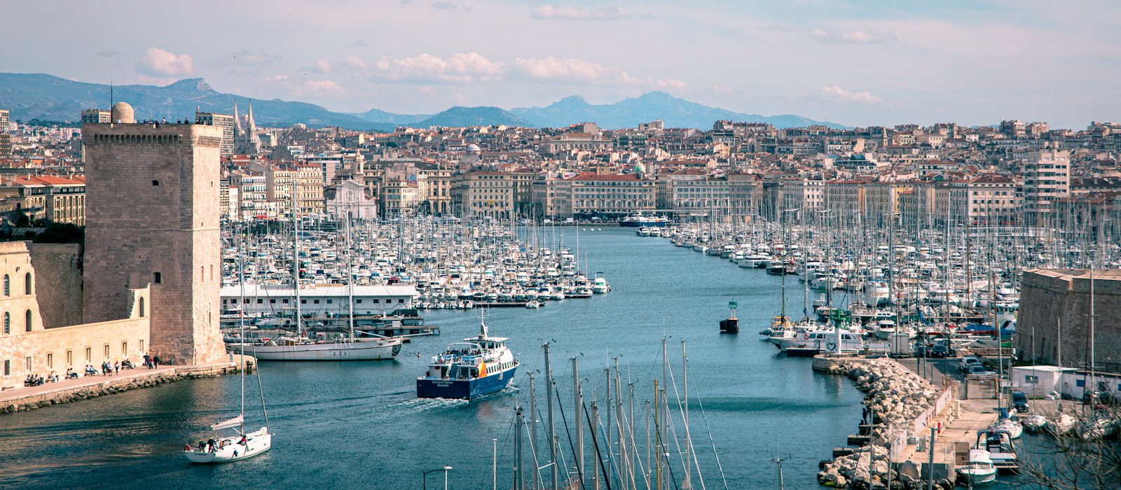 L'entrée du Vieux-Port de Marseille, entre le fort Saint-Jean et le fort Saint-Nicolas, avec ses voiliers et la ville en arrière-plan