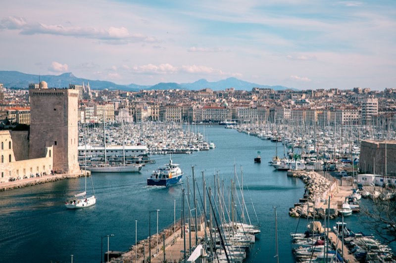L'entrée du Vieux-Port de Marseille, entre le fort Saint-Jean et le fort Saint-Nicolas, avec ses voiliers et la ville en arrière-plan