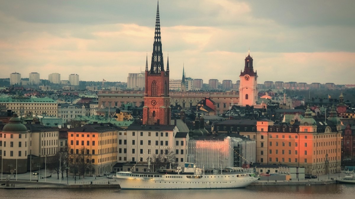 L'île de Riddarholmen à Stockholm, dominée par la flèche ajourée de son église, avec un bateau blanc amarré au quai