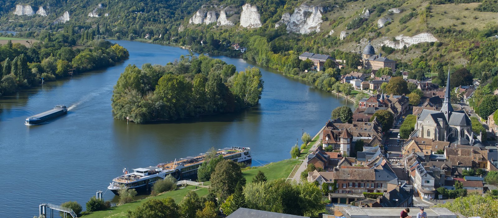 Vue plongeante sur la Seine aux Andelys, avec un bateau de croisière fluviale amarré le long de la rive