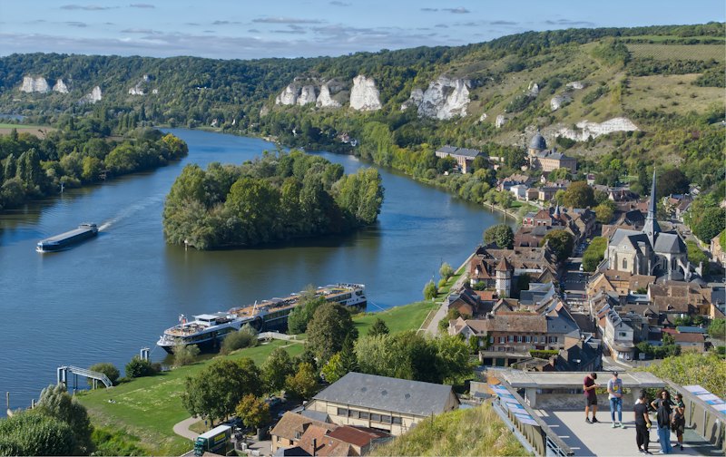Vue plongeante sur la Seine aux Andelys, avec un bateau de croisière fluviale amarré le long de la rive