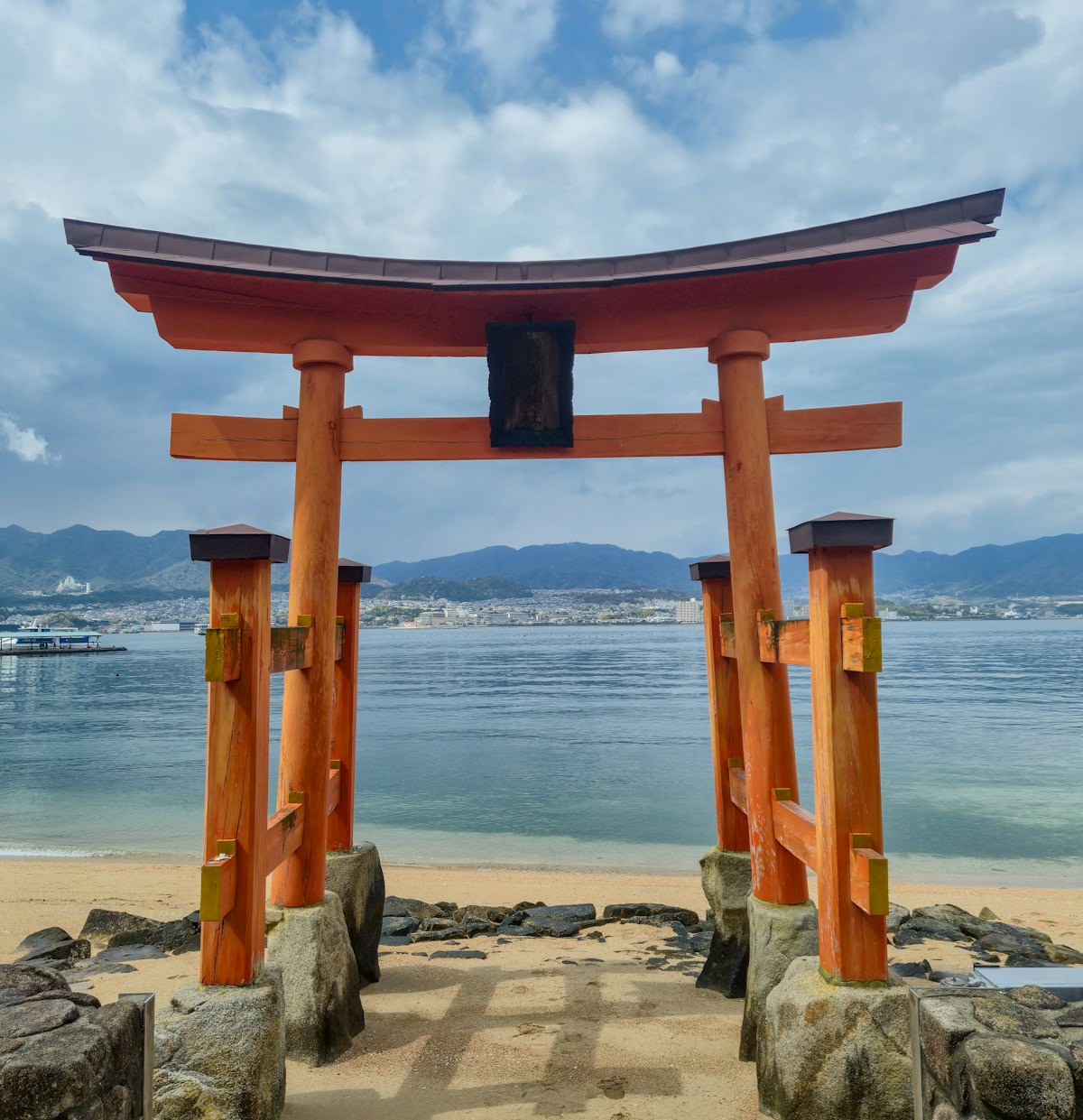 Torii orange dressé au bord de la mer sur une côte japonaise