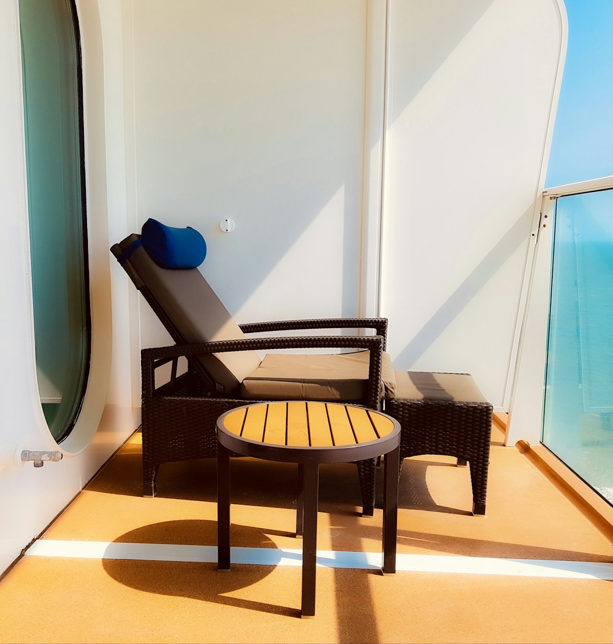 Balcon privatif de suite avec transat et table basse à bord d'un navire